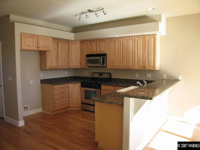 2060 Dickerson Road Reno, NV 89503 - Photo 3 of 5 a kitchen with granite countertop a stove a sink and a microwave