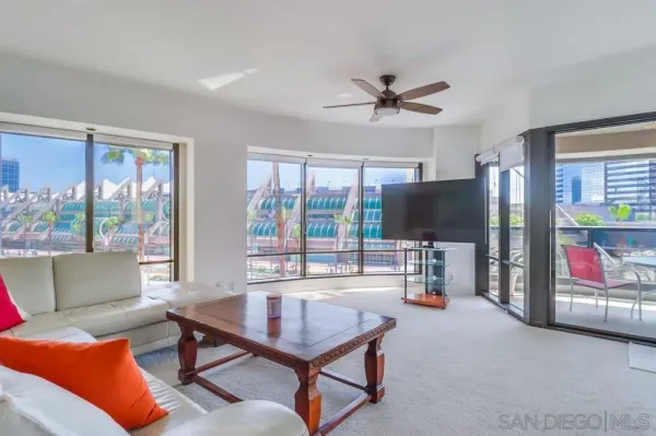 a living room with furniture a flat screen tv and a large window