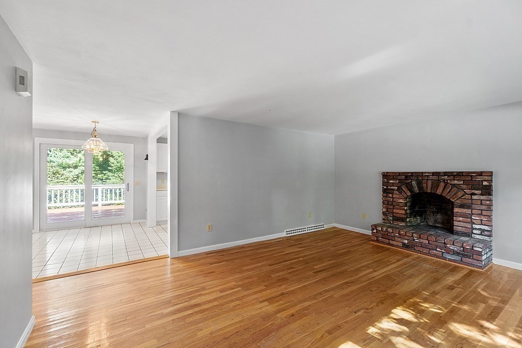 11 Mc Intosh Road Chelmsford, MA 01824 - Photo 8 of 20 a view of empty room with wooden floor and fireplace