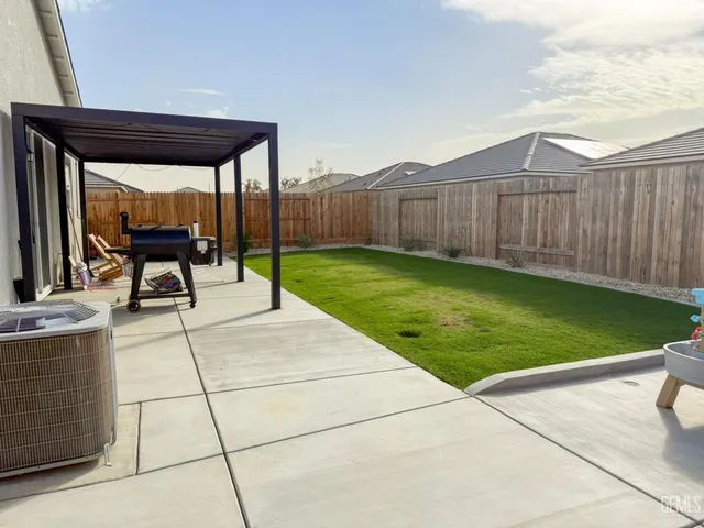 a view of a backyard with table and chairs and a yard