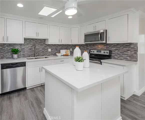a kitchen with sink a microwave and cabinets
