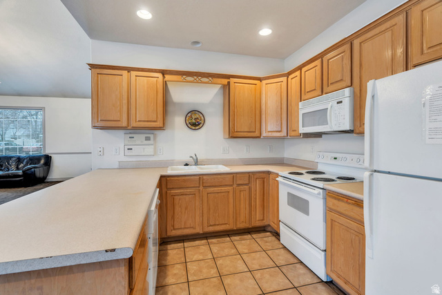986 Independence Avenue Provo, UT 84604 - Photo 23 of 29 Kitchen featuring wood cabinetry, white appliances, a double basin sink, and tile flooring