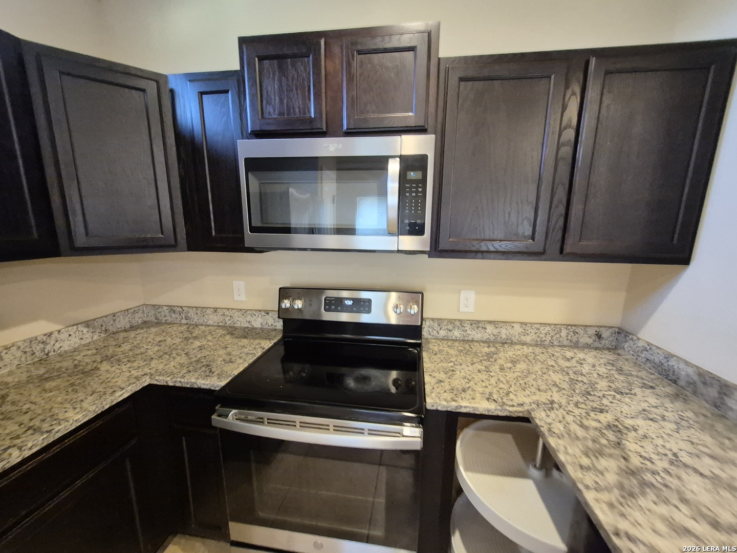 6515 Marcel Way, Unit 101 San Antonio, TX 78233 - Photo 7 of 28 a kitchen with granite countertop wooden cabinets and stainless steel appliances