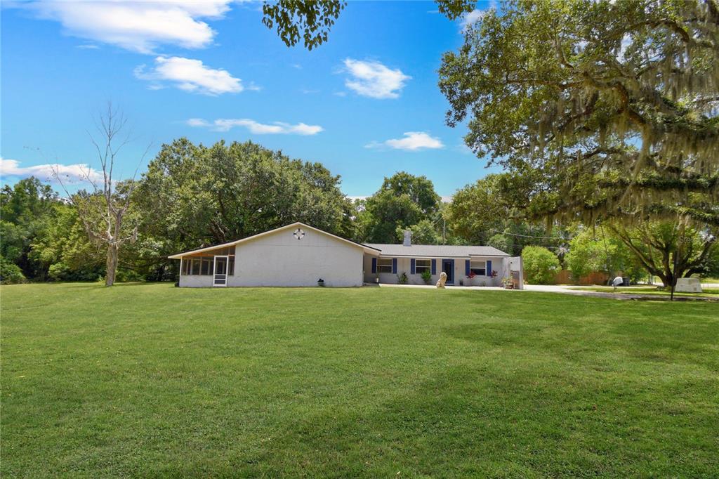 2706 Old Moultrie Road St. Augustine, FL 32086 - Photo 14 of 18 a house that is sitting in the grass with large trees