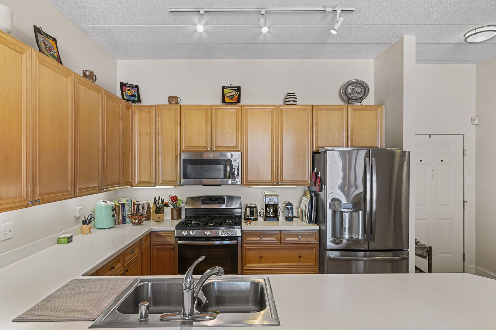 1301 West Washington Boulevard, Unit 508 Chicago, IL 60607 - Photo 5 of 17 a kitchen with stainless steel appliances granite countertop a refrigerator stove and sink
