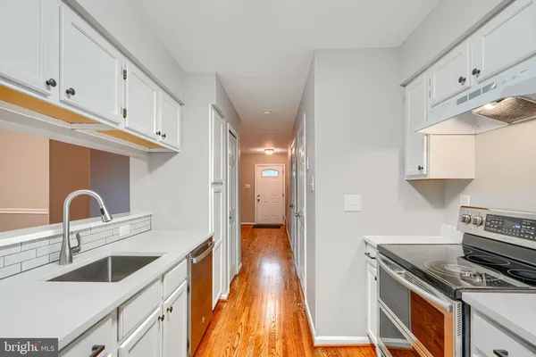 a kitchen with granite countertop a stove and a sink