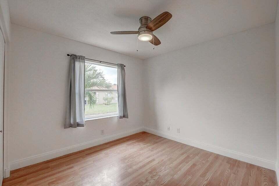10758 Lake Jasmine Drive Boca Raton, FL 33498 - Photo 12 of 34 wooden floor in an empty room with a window
