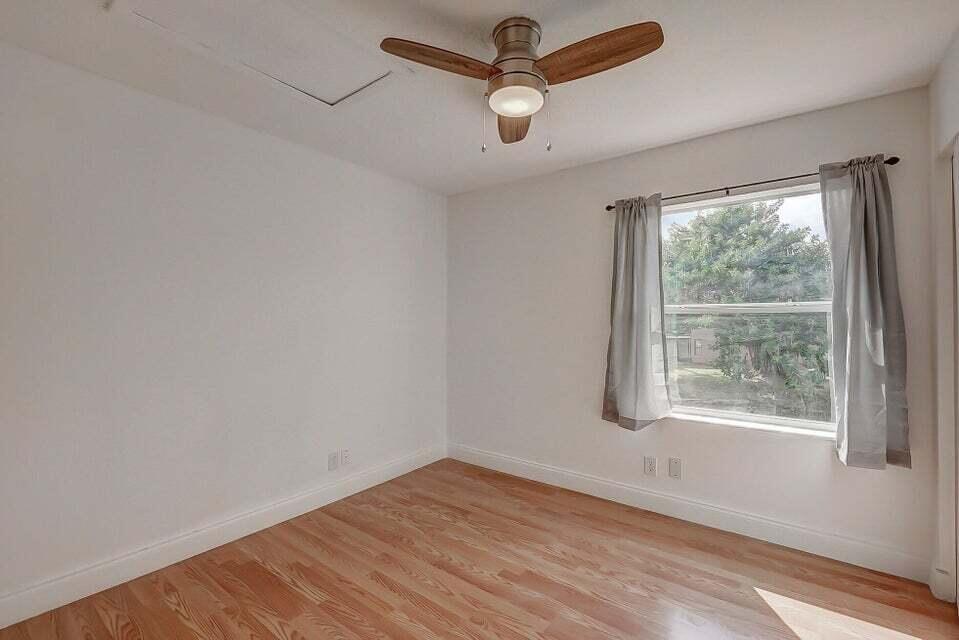 10758 Lake Jasmine Drive Boca Raton, FL 33498 - Photo 14 of 34 a view of empty room with wooden floor and fan