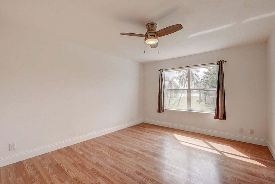 10758 Lake Jasmine Drive Boca Raton, FL 33498 - Photo 16 of 34 wooden floor in an empty room with a window