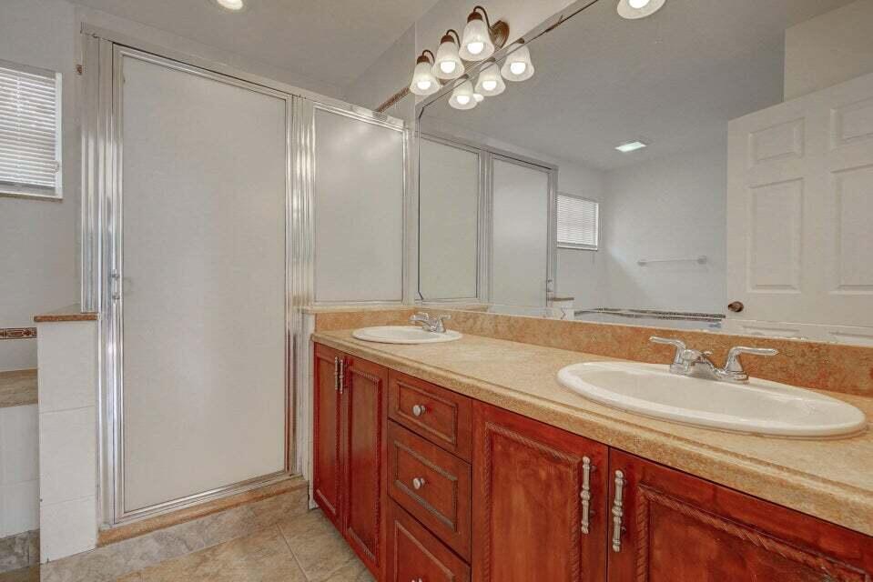 10758 Lake Jasmine Drive Boca Raton, FL 33498 - Photo 18 of 34 a bathroom with a granite countertop sink a light fixture and a mirror
