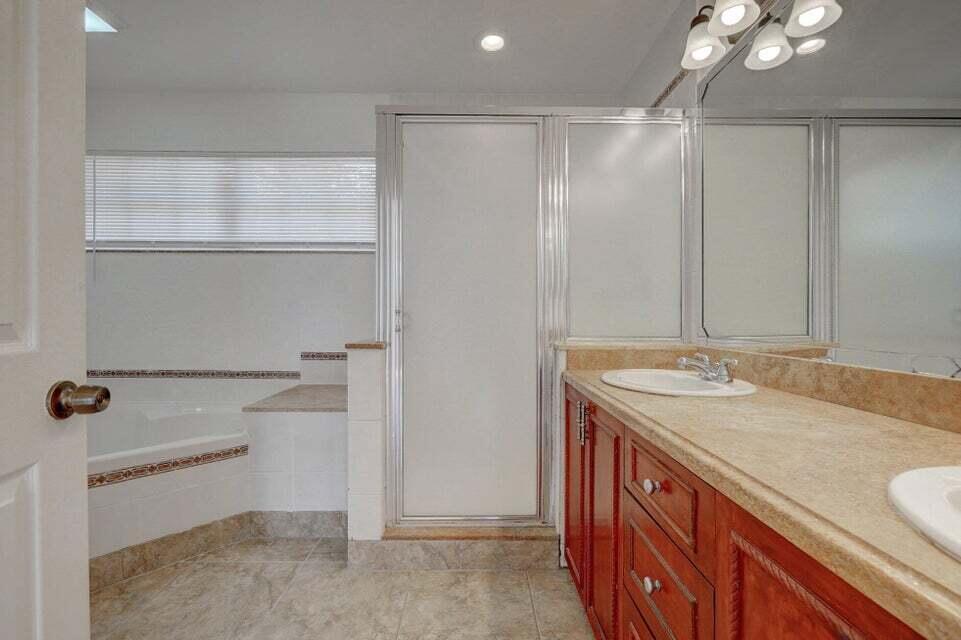 10758 Lake Jasmine Drive Boca Raton, FL 33498 - Photo 19 of 34 a bathroom with a granite countertop sink and a mirror
