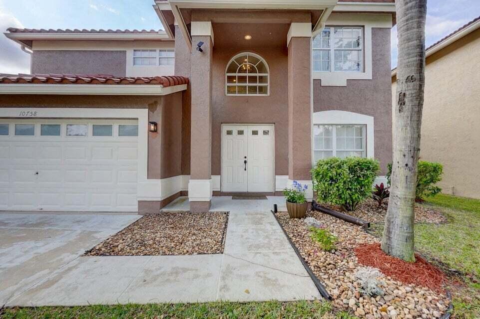 10758 Lake Jasmine Drive Boca Raton, FL 33498 - Photo 2 of 34 front view of a brick house with a small yard