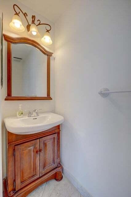 10758 Lake Jasmine Drive Boca Raton, FL 33498 - Photo 23 of 34 a bathroom with a sink a mirror and vanity