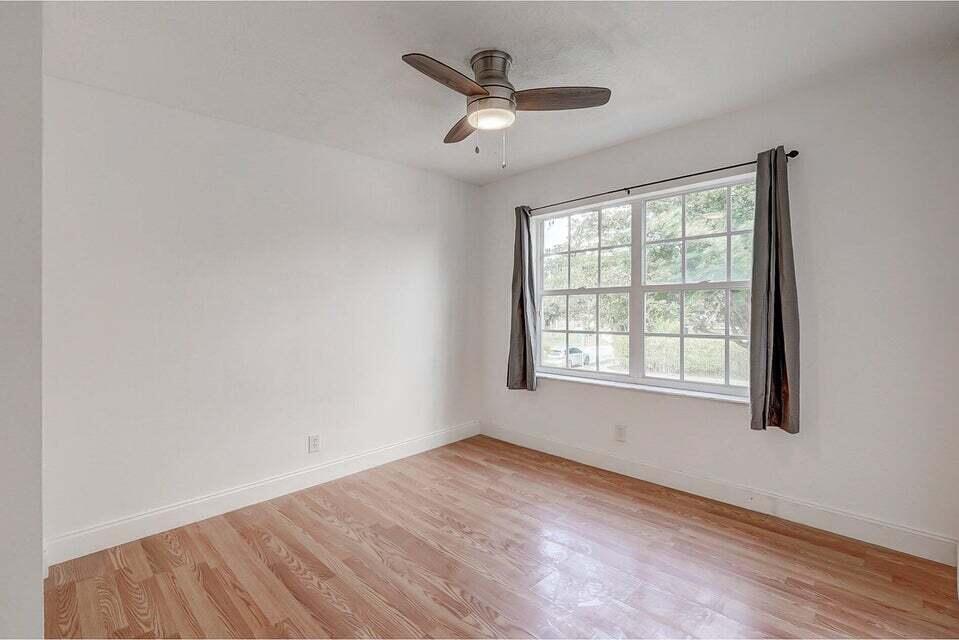 10758 Lake Jasmine Drive Boca Raton, FL 33498 - Photo 24 of 34 wooden floor in an empty room with a window