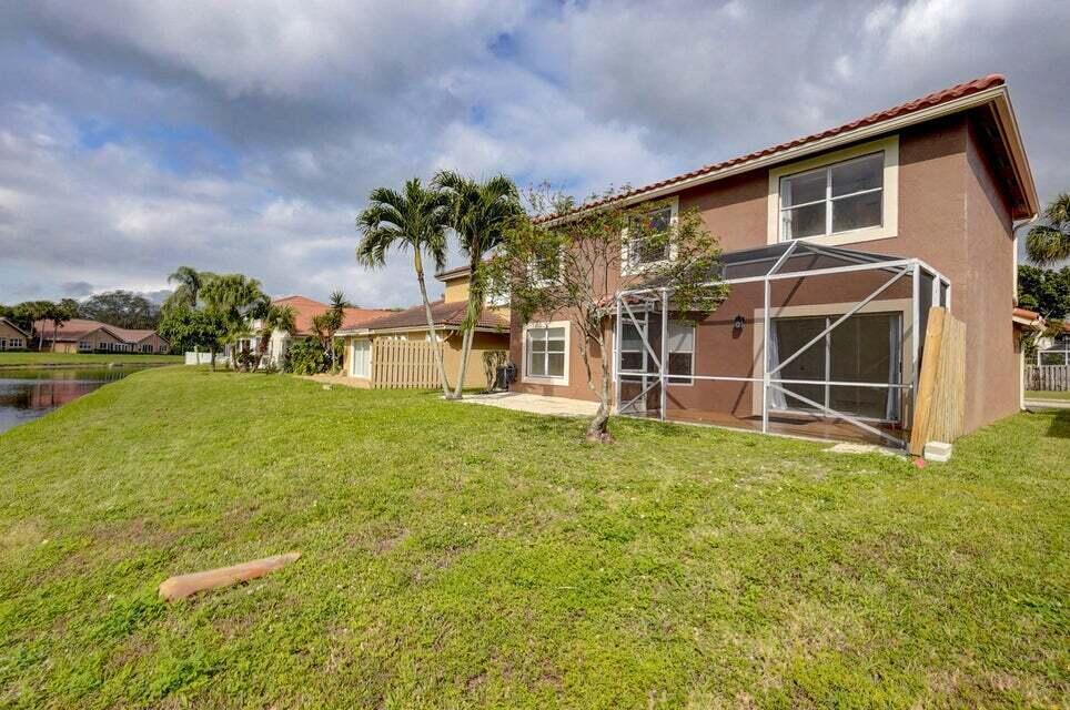 10758 Lake Jasmine Drive Boca Raton, FL 33498 - Photo 32 of 34 a front view of a house with a yard