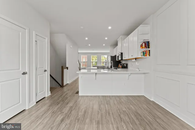 a view of kitchen with wooden floor and electronic appliances