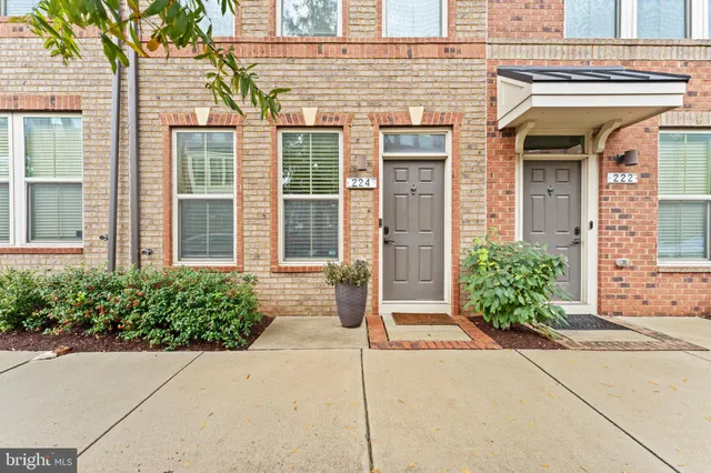 front view of a brick house with potted plants