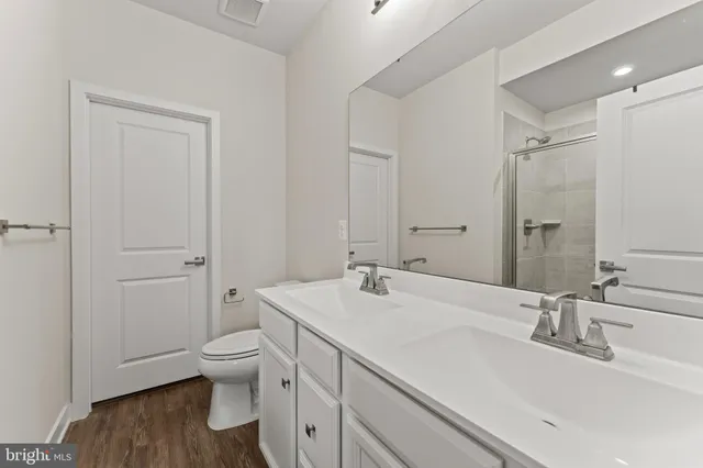 a bathroom with a sink toilet double vanity and tub