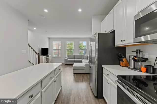 a kitchen with a refrigerator a stove and a cabinets with wooden floor