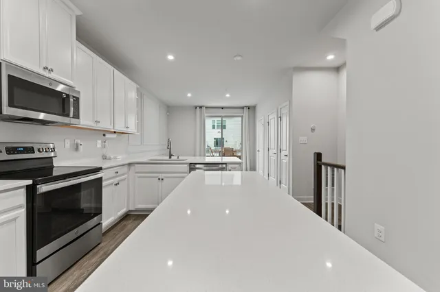 a kitchen with stainless steel appliances a stove sink microwave and cabinets