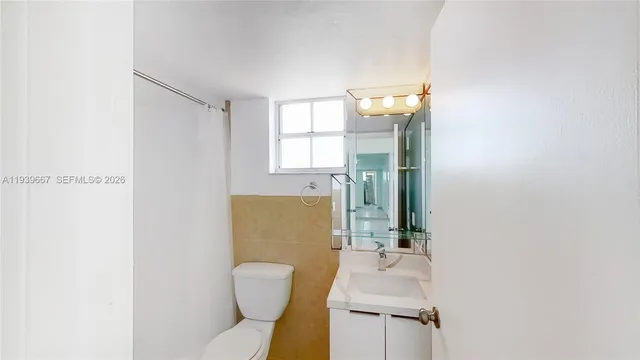 a bathroom with a sink mirror vanity and toilet