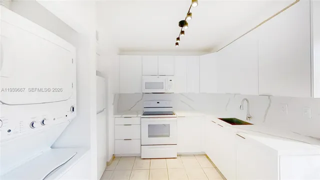 a kitchen with white cabinets and white appliances