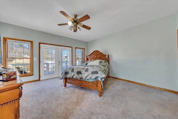 a bedroom with a bed and large windows