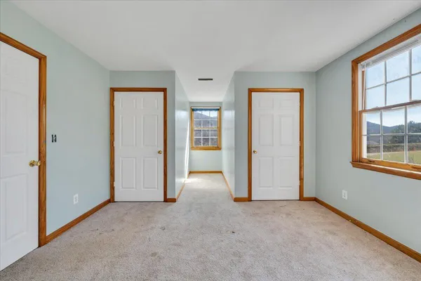 an empty room with windows and closet