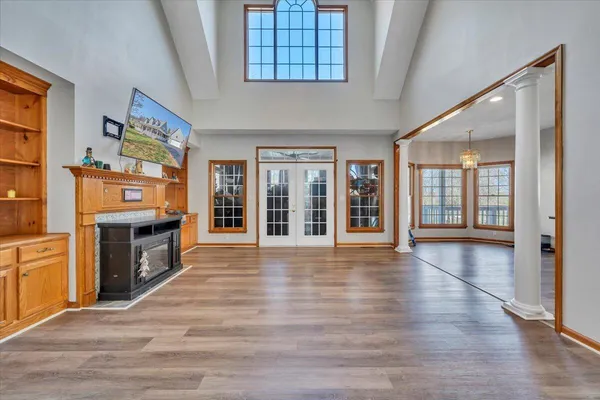 a view of an empty room with window and wooden floor