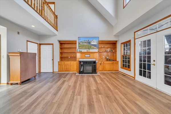 a view of empty room with wooden floor and fireplace