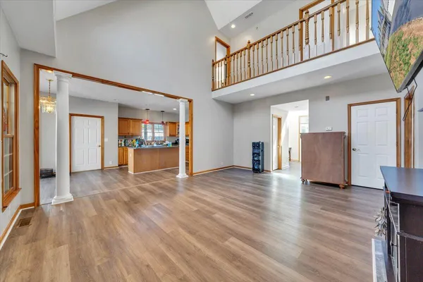 a view of a hallway with wooden floor and a kitchen