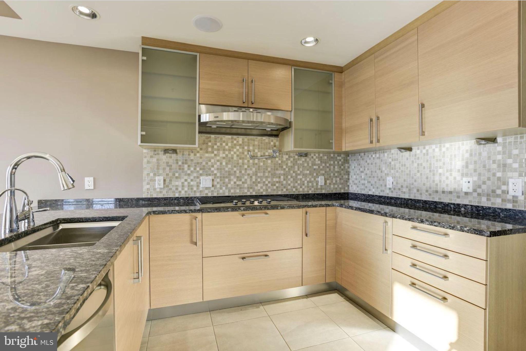 801 Key Highway, Unit 413 Baltimore, MD 21230 - Photo 18 of 40 a kitchen with granite countertop a sink a stove and cabinets