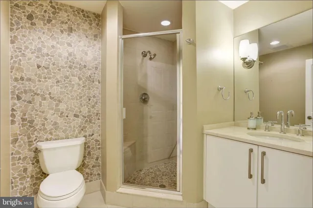 a bathroom with a granite countertop sink toilet and shower
