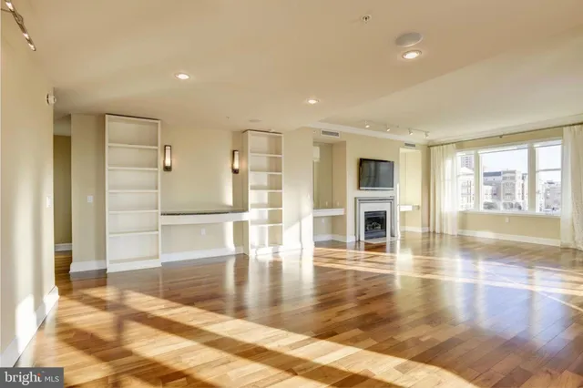 a view of empty room with wooden floor and floor to ceiling window