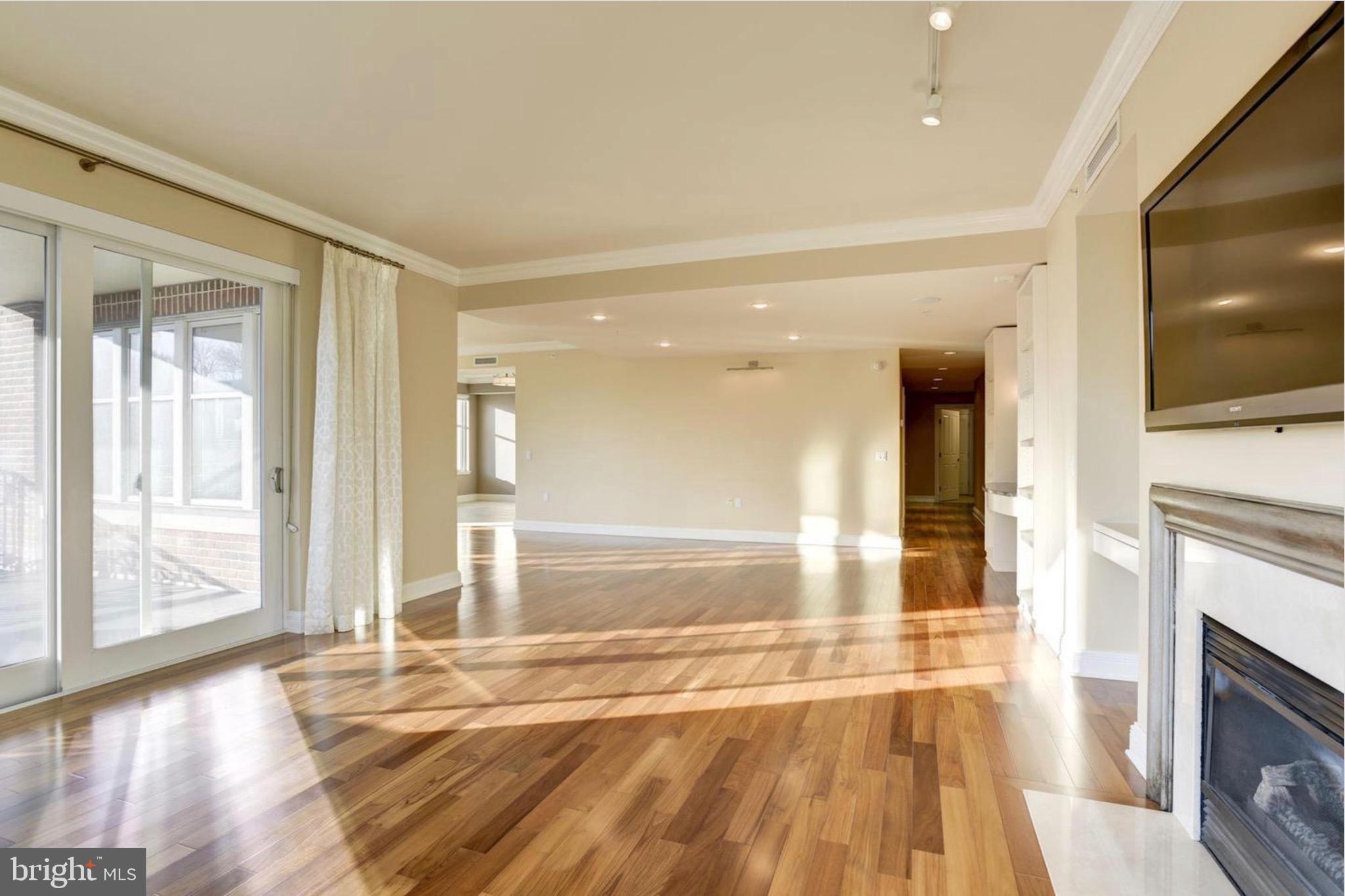 801 Key Highway, Unit 413 Baltimore, MD 21230 - Photo 9 of 40 a view of an empty room with wooden floor and a fireplace