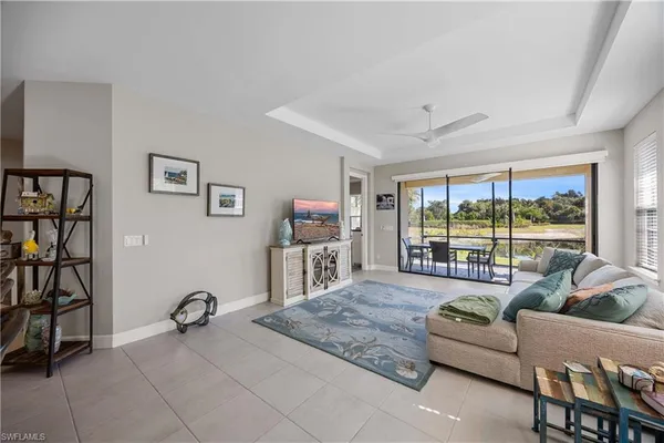 a living room with furniture a flat screen tv and a large window
