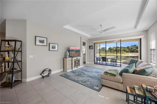 a living room with furniture a flat screen tv and a large window