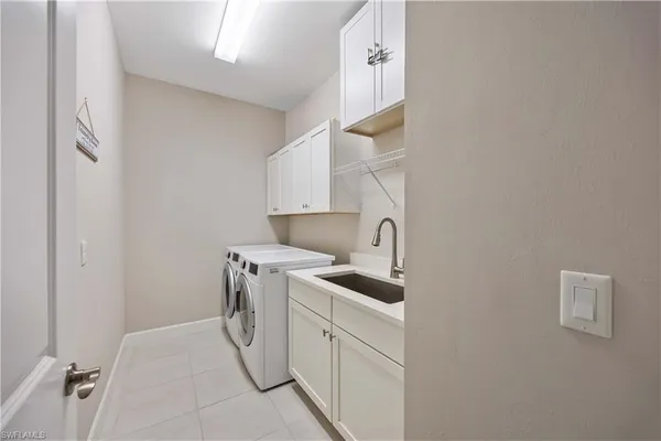 a utility room with cabinets washer and dryer