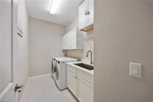 a utility room with cabinets washer and dryer