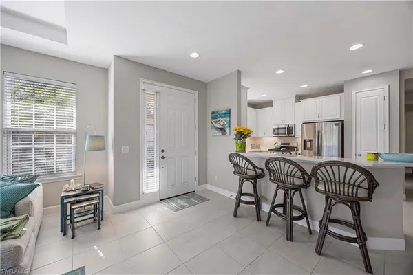 a kitchen with granite countertop a dining table chairs and a refrigerator