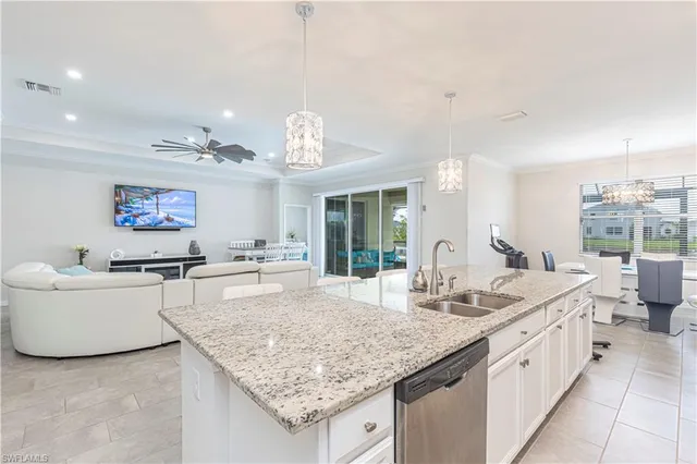 a open kitchen with granite countertop a sink and dishwasher with a dining table