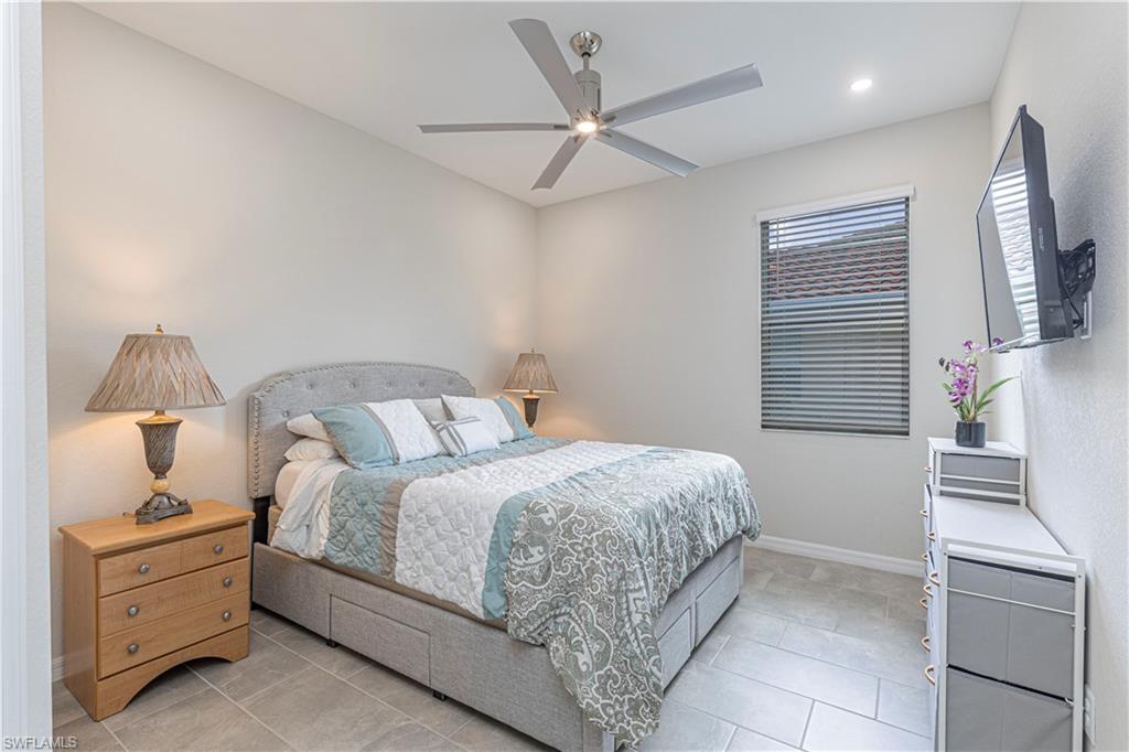 2079 Vermont Lane Naples, FL 34120 - Photo 10 of 12 a bedroom with a bed and a chandelier