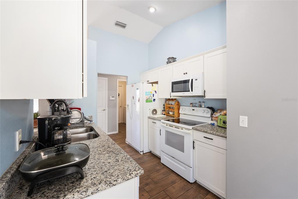 2219 Southwest 146th Loop Ocala, FL 34473 - Photo 12 of 32 a kitchen with white cabinets and appliances