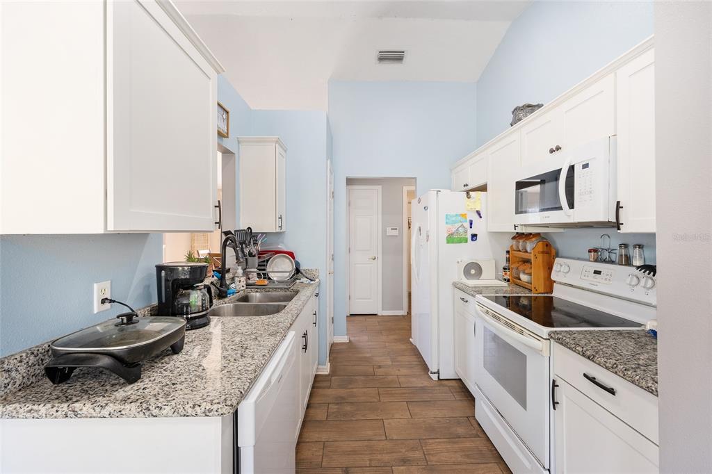 2219 Southwest 146th Loop Ocala, FL 34473 - Photo 14 of 32 a kitchen with kitchen island granite countertop a sink stove and cabinets