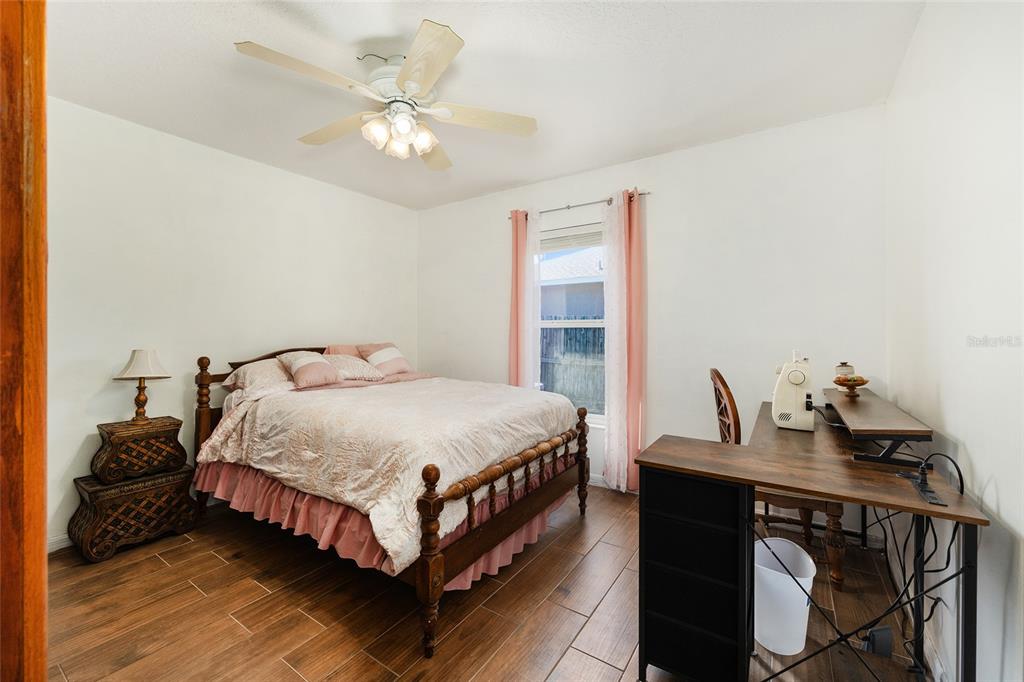 2219 Southwest 146th Loop Ocala, FL 34473 - Photo 24 of 32 a bedroom with a bed and a chandelier