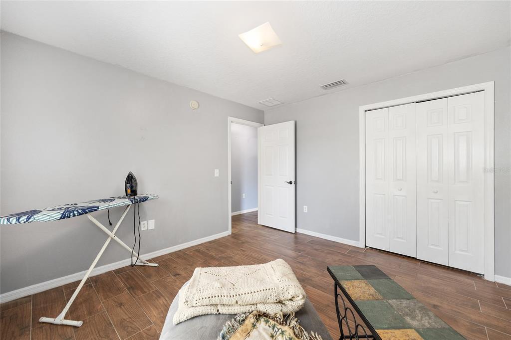 2219 Southwest 146th Loop Ocala, FL 34473 - Photo 27 of 32 a bedroom with a bed and a chandelier fan