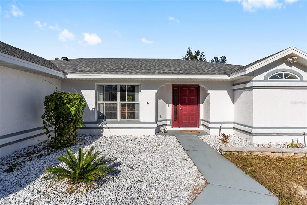 2219 Southwest 146th Loop Ocala, FL 34473 - Photo 3 of 32 a front view of a house with a yard and seating space