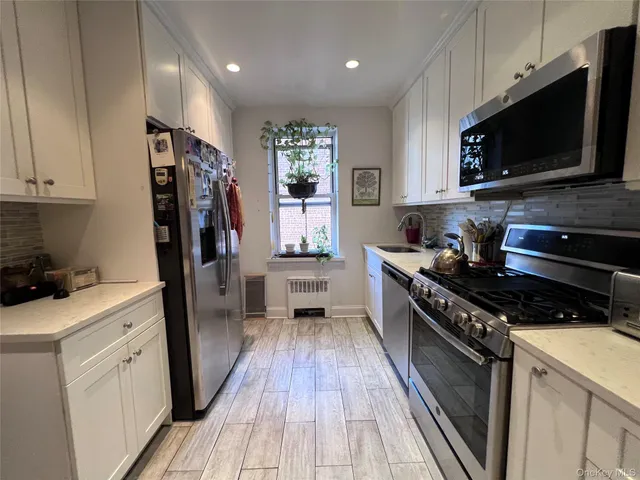 a kitchen with stainless steel appliances a stove sink microwave and cabinets