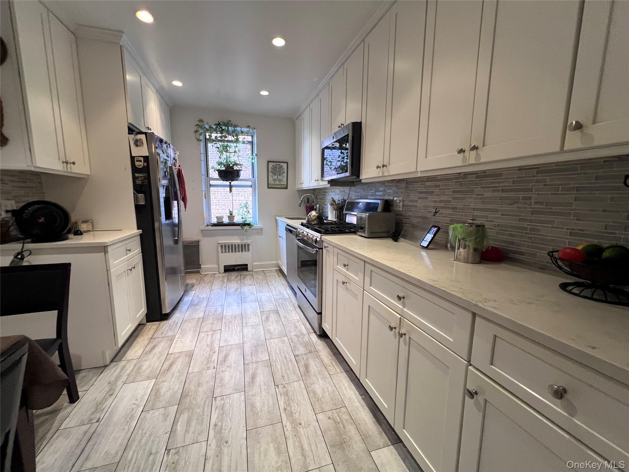 2080 Barnes Avenue, Unit 5C Bronx, NY 10462 - Photo 4 of 13 a kitchen with cabinets and wooden floor