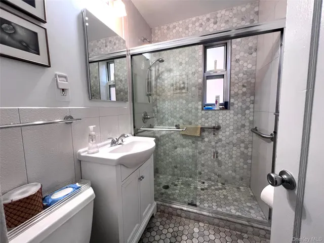 a bathroom with a sink mirror and shower